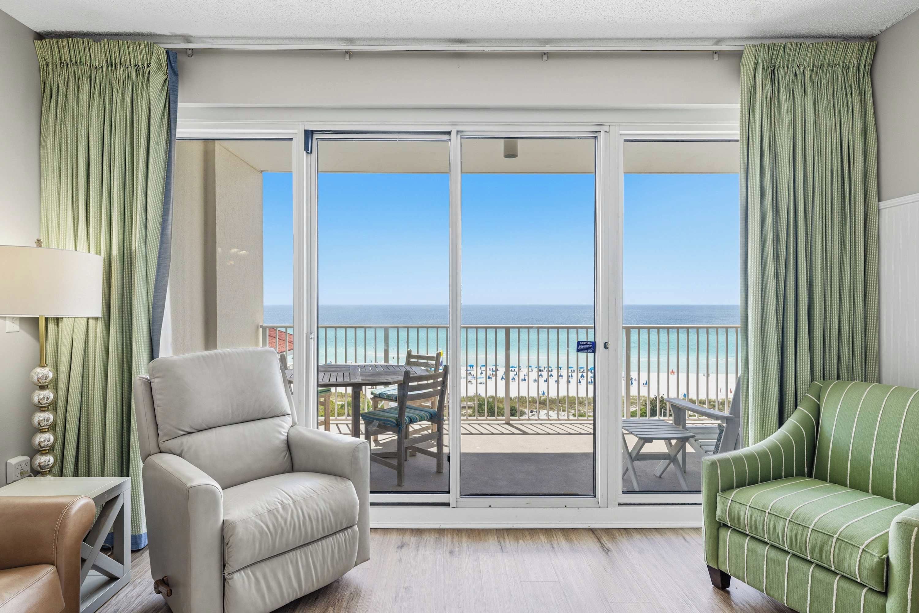 Une chambre dotée d’une porte-fenêtre coulissante donnant sur un balcon avec vue sur la plage.