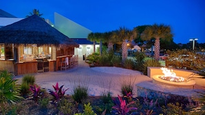 A resort with a thatched-roof bar, outdoor seating, a fire pit, and a pool area. - Beachfront escape with Gulf views, pool access (Miramar Beach)