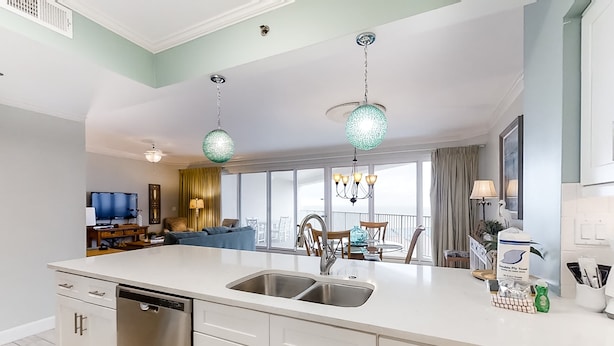 A modern kitchen with a large island, stainless steel appliances, and pendant lighting. - Beachfront escape with Gulf views, pool access (Miramar Beach)