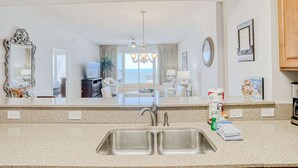 Eine moderne Küche mit einer doppelten Spüle, Granit Arbeitsplatten und Blick zum Wohnbereich.