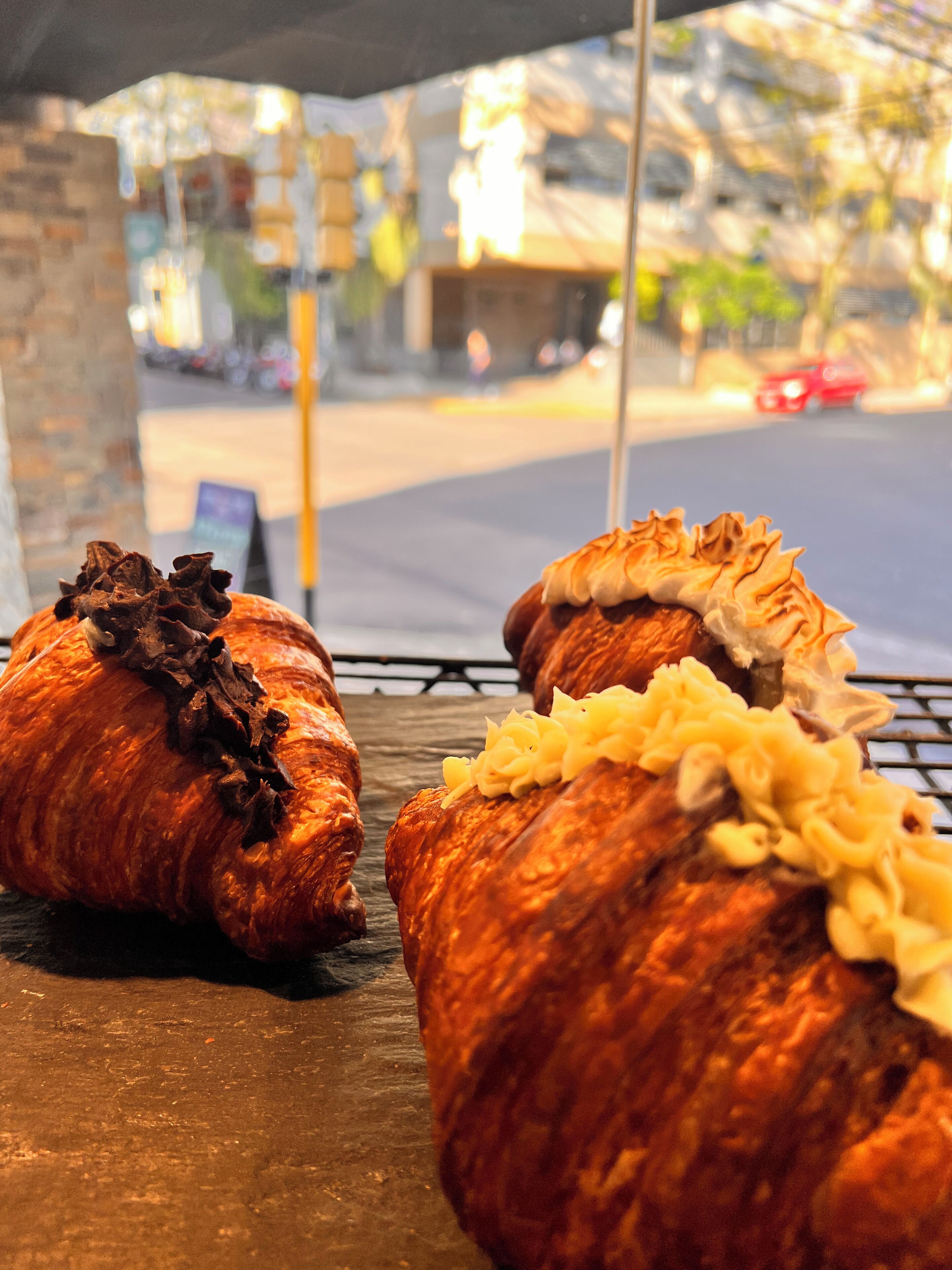 Dos croissants de chocolate y queso sobre una bandeja.