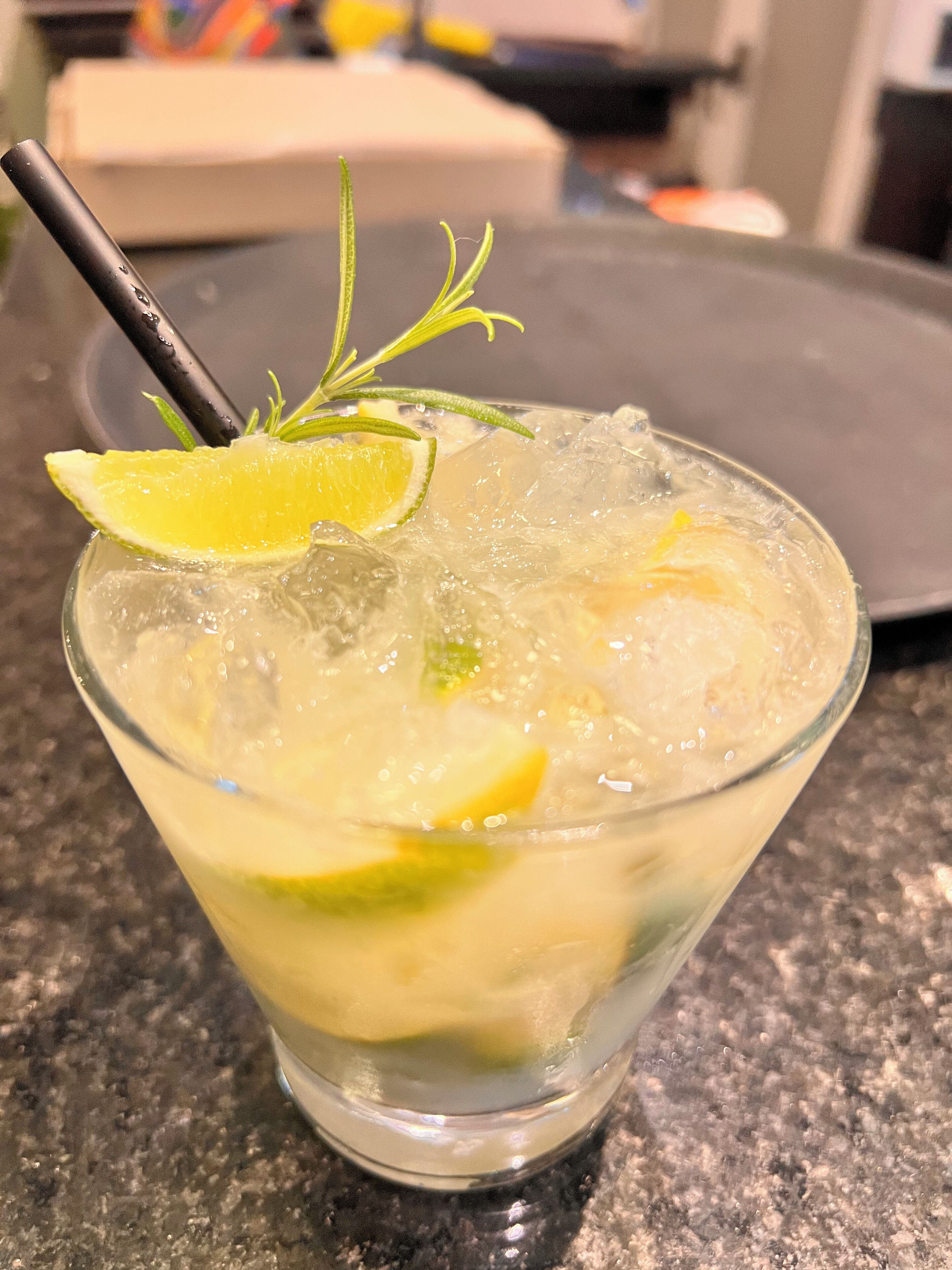 Ein Cocktail mit Eiswürfeln und einem Limettenschnitz als Dekoration in einem Glas.