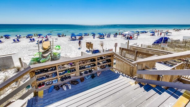 A beach view with a wooden deck and a shoe rack. - Gulf-front condo: 2BR, pools, direct beach (Miramar Beach)
