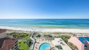 Un resort con piscina, vista al mar y sombrillas de playa.