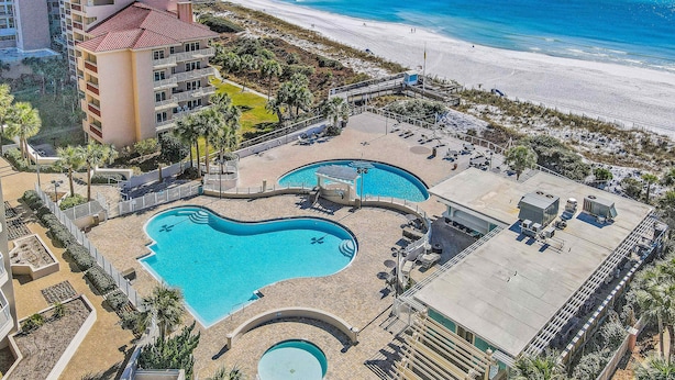 A hotel with multiple swimming pools, a beach, and a high-rise building. - Beachfront Resort with Gulf Views & Pool (Miramar Beach)