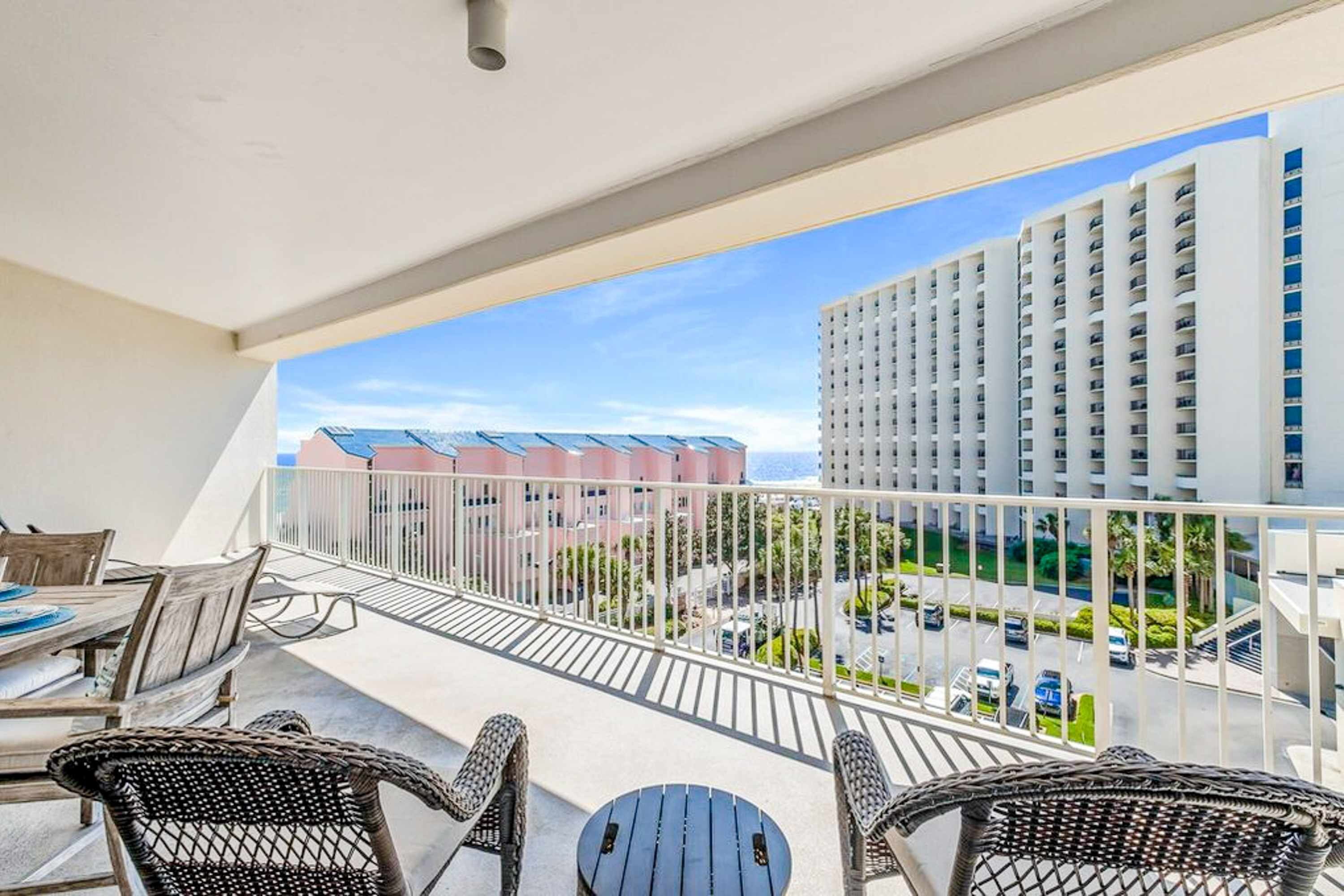 Ein Balkon mit Korbmöbeln und Blick auf ein Hotelgebäude.