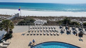 A poolside area with lounge chairs, a pool, and a view of the beach and ocean. - 2BR Beachfront, Gulf Views, Sleeps 6 (Miramar Beach)