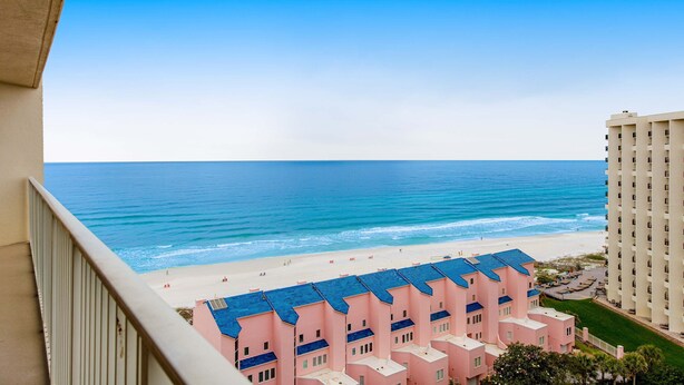 A beachfront hotel with multiple pink buildings, a sandy beach, and the ocean in the background. - Exclusive Gulf-Front Condo with Balcony (Miramar Beach)