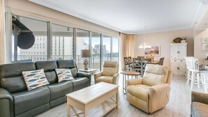 Un salón espacioso con sofá, sillones, una mesa de centro y una zona de comedor con mesa y sillas.