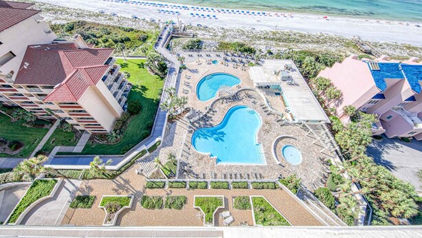 An aerial view of a resort with multiple swimming pools, a beach, and a parking area. - Exclusive Gulf Views, Private Balcony (Miramar Beach)