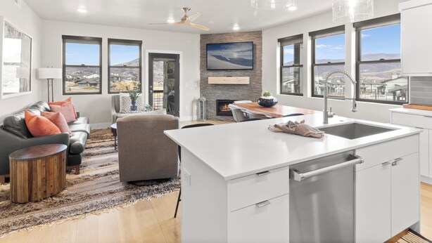 A modern kitchen with a central island, large windows, and a view of the landscape. - Mayflower Lakeside 104 | Reservoir + Mountain View | Full Kitchen | Private Bedrooms (Heber City)
