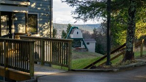Un quartier résidentiel avec une terrasse en bois, une aire de jeux verdoyante et une maison dont la porte porte le numéro 4.