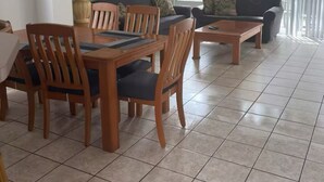 A dining area with a wooden table and chairs, a sofa, and a ceiling fan. - Home in Kissimmee near Disney and Universal (Kissimmee)