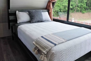 A neatly made bed with a white quilt and a striped throw blanket. - Pepe's Village Luxury Aqua Dream Villa (Rincón)