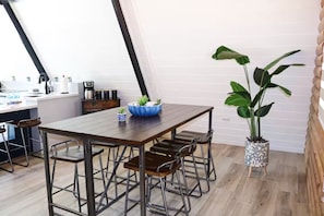 A dining area with a wooden table and metal chairs, a blue decorative bowl, and a large potted plant. - Pepe's Village Luxury Aqua Dream Villa (Rincón)