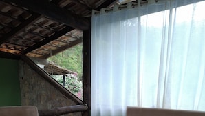 A cozy room with two beige sofas, a small round table with a lamp, and a white furry rug. - Hotel fazenda casa mato  (Taubate)