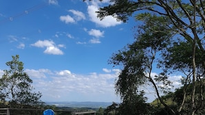 A swimming pool with stone tiles, surrounded by a grassy area and trees. - Hotel fazenda casa mato  (Taubate)