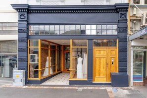 A boutique hotel with a dark facade, large windows, and a wooden entrance door. - NYC Style Loft Apartment (Dunedin)