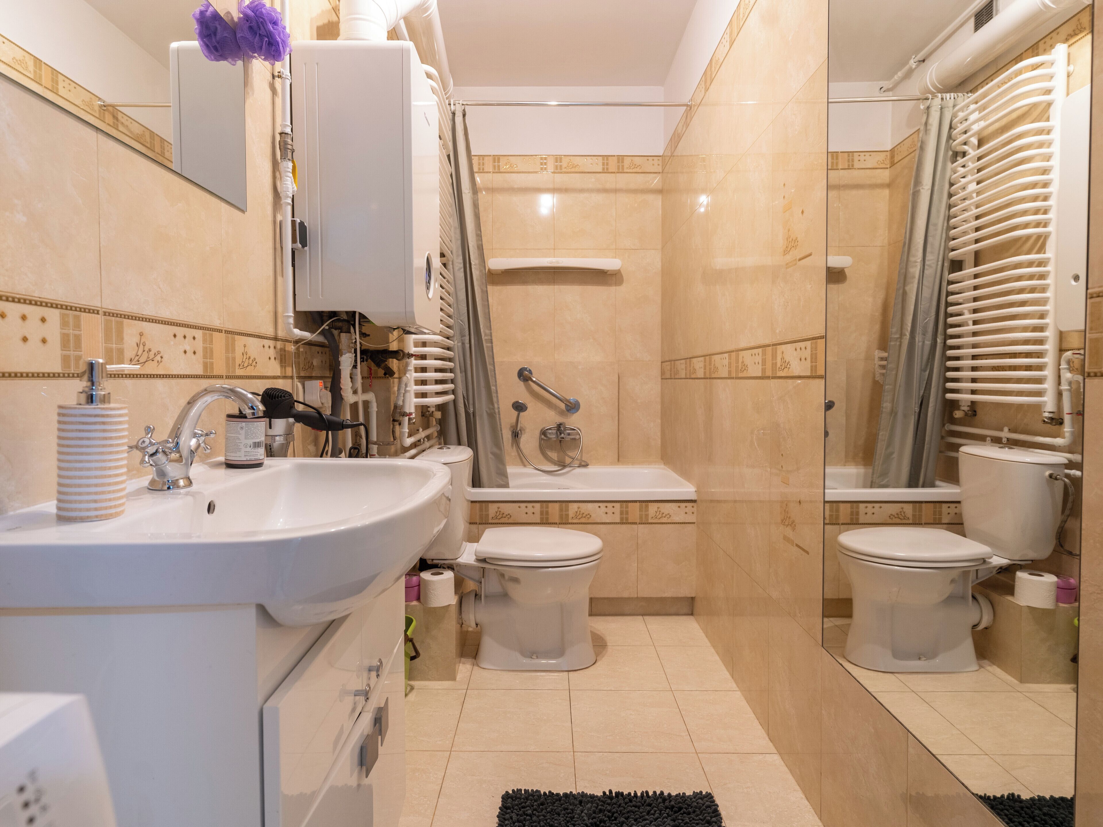 Une salle de bain moderne équipée d’un lavabo, de deux toilettes, d’une baignoire et d’une douche.