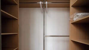 A wooden wardrobe with a mirrored door and a metal rod for hanging items. - Solidarności City View Apartment (Warszawa)