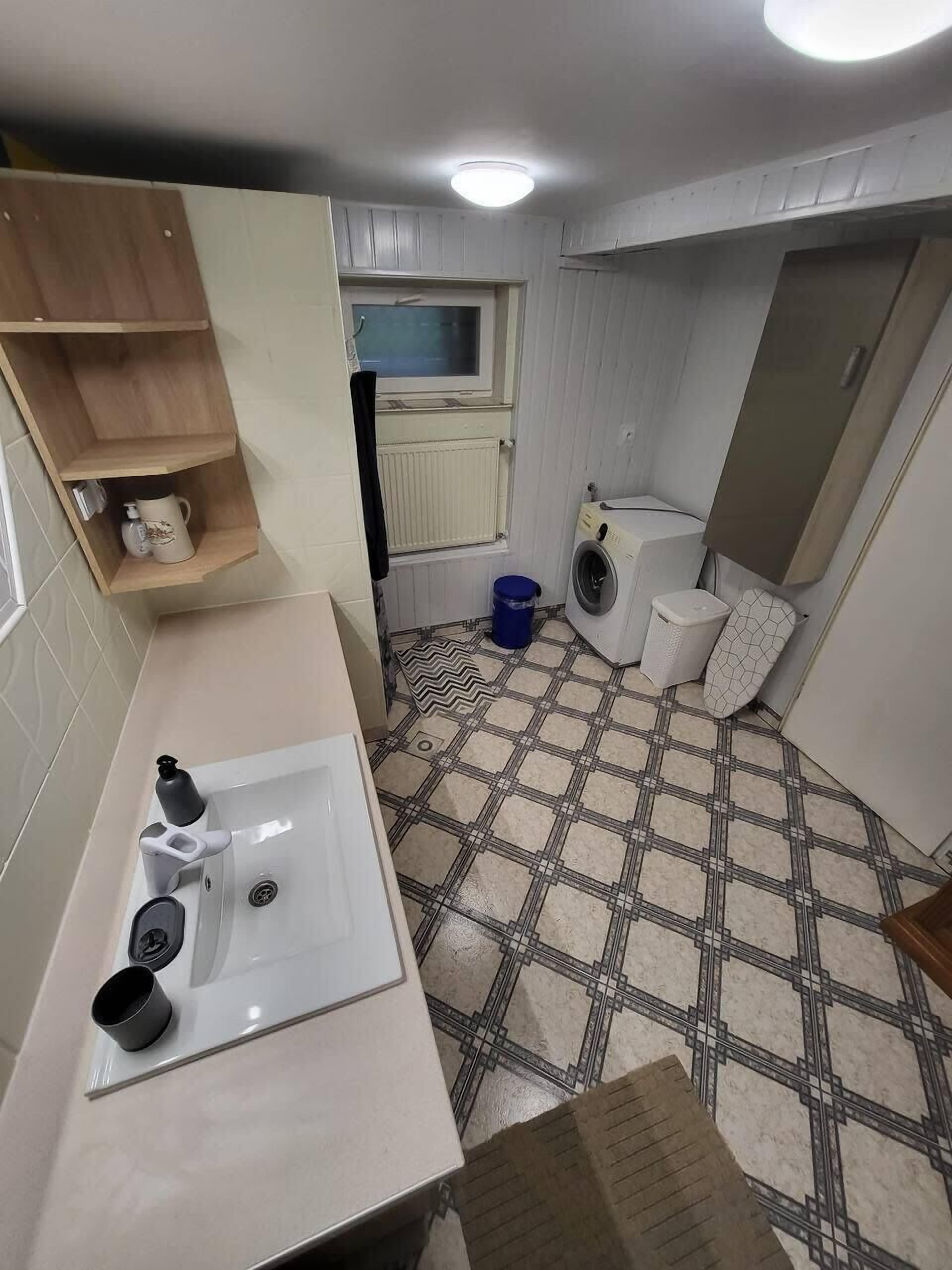 Ein kleines Badezimmer mit Waschbecken, Toilette und Waschmaschine.