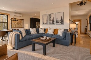 Ein modernes Wohnzimmer mit einer Eckcouch, einem Couchtisch und einer Weltkarte als Wandbild.