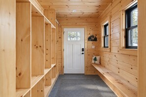 A wooden hallway with a door, shelves, a bench, and a window. - Ninth Peak | Golf and Spa Retreat with Trails, Hot Tub & Sauna (Bethel)