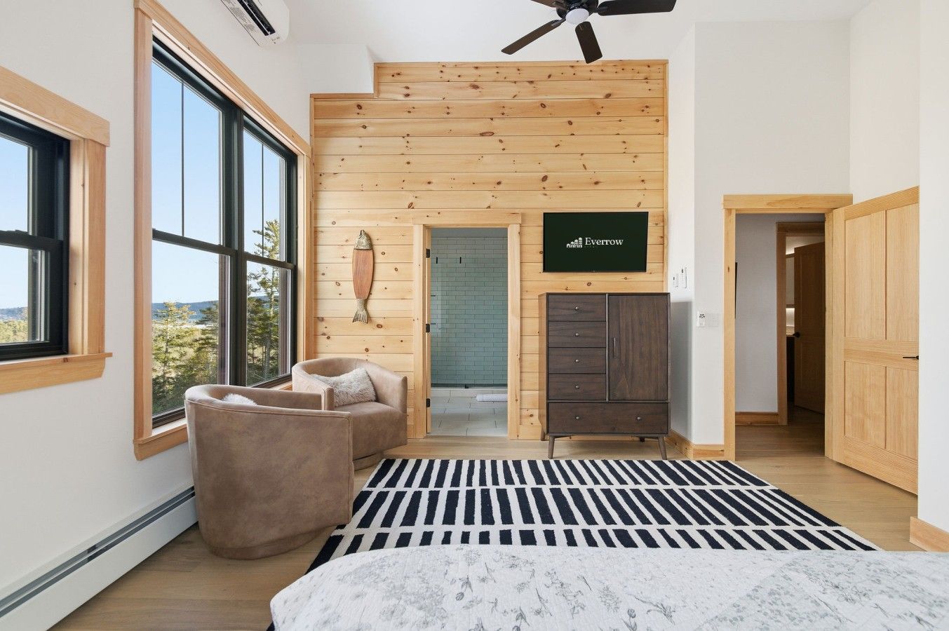 The primary suite’s vaulted ceiling, sitting area, television and ensuite entrance.