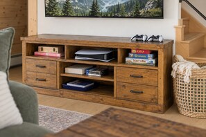 Eine Holz-Unterhaltungsanlage mit Videospielen, Brettspielen und Büchern.