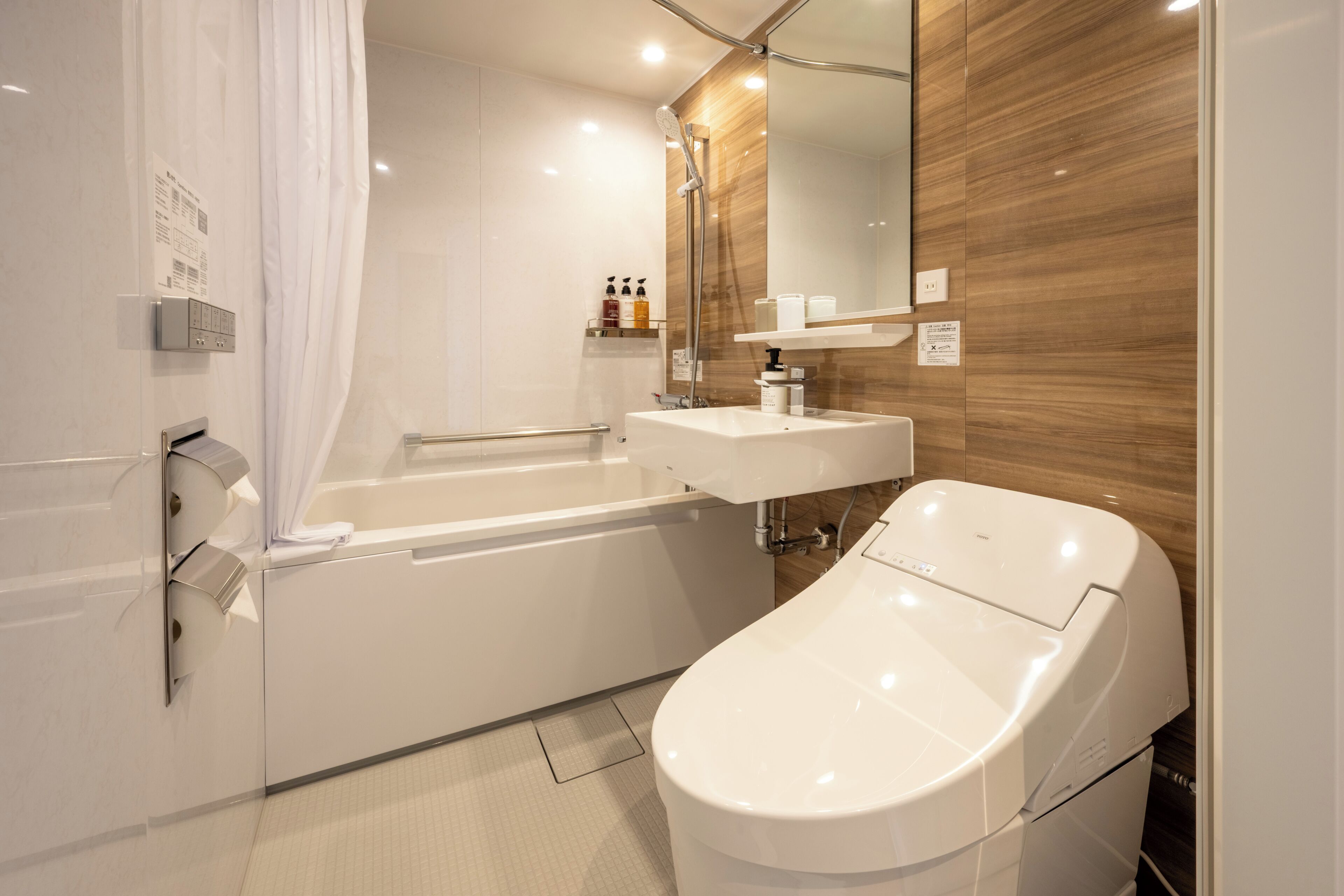 Un baño moderno con bañera, inodoro independiente, tocador con espejo y zona de ducha.