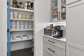 A kitchen with white cabinets, a coffee machine, and storage containers. - Epic House for Groups: 10 Mins to Sunday River (Bethel)