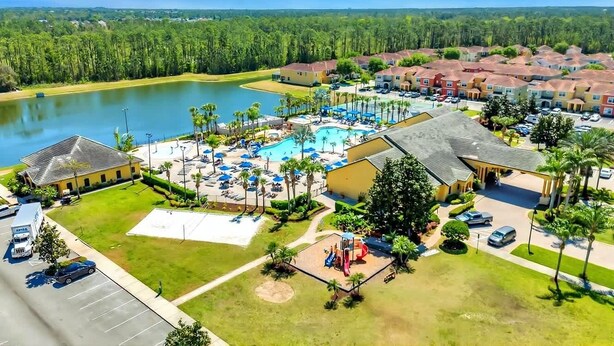 A residential area with a swimming pool, multiple houses, and a large body of water. - Paradise 4Bd w Private Pool & Waterpark 2941 (Kissimmee)