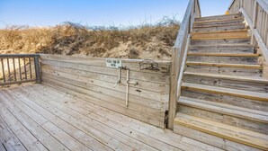 A wooden staircase leading up to a beach area with a sign that says "Please turn off water." - Ocean's Outside: Relaxing Oceanfront Escape (Kill Devil Hills)