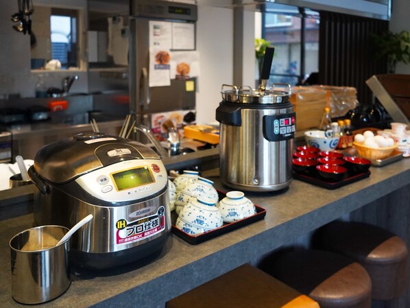 A kitchen counter with a rice cooker, a pressure cooker, and various kitchen utensils. - TORANOMONHOLIC HOTEL (Tokyo)