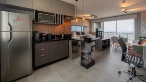 A modern kitchen with a built-in microwave, stainless steel appliances, and a coffee station. - Modern studio apartment with queen-size bed in Cityplex Osasco. (Osasco)