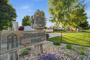 Ein Holzschild für den Stokely's Park mit einer Darstellung eines Gebäudes und einer Parkszene.