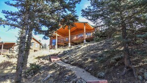 Une cabane en bois dotée d’un porche et d’un escalier en pierre menant à l’entrée.