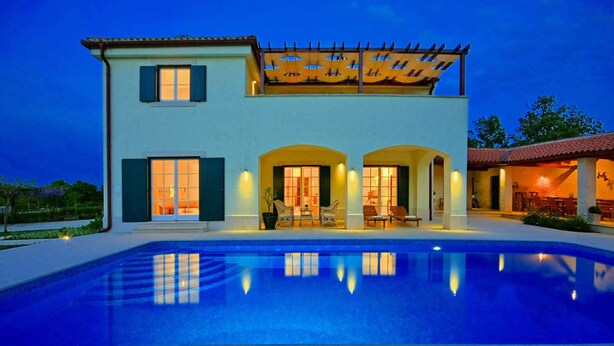 A two-story house with a swimming pool in front, featuring a covered patio area with outdoor seating. - Villa with pool and air conditioning (Orbanići)