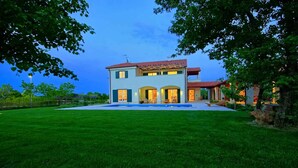 A two-story house with a swimming pool, surrounded by a well-maintained lawn and trees. - Villa with pool and air conditioning (Orbanići)