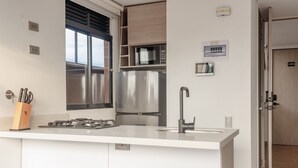 Uma cozinha moderna com geladeira de aço inoxidável, forno embutido e fogão a gás.