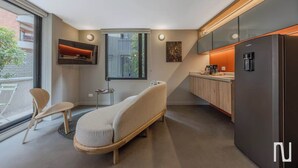 Een moderne keuken met een inbouwkoelkast, een eethoek met een stoel en een raam met uitzicht.