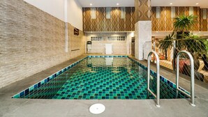 An indoor swimming pool with a tiled floor and a brick wall on one side. - Ja Siam City (Pattaya)