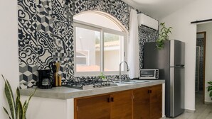 Een moderne keuken met een gasfornuis, een ingebouwde oven, een spoelbak en een koelkast.
