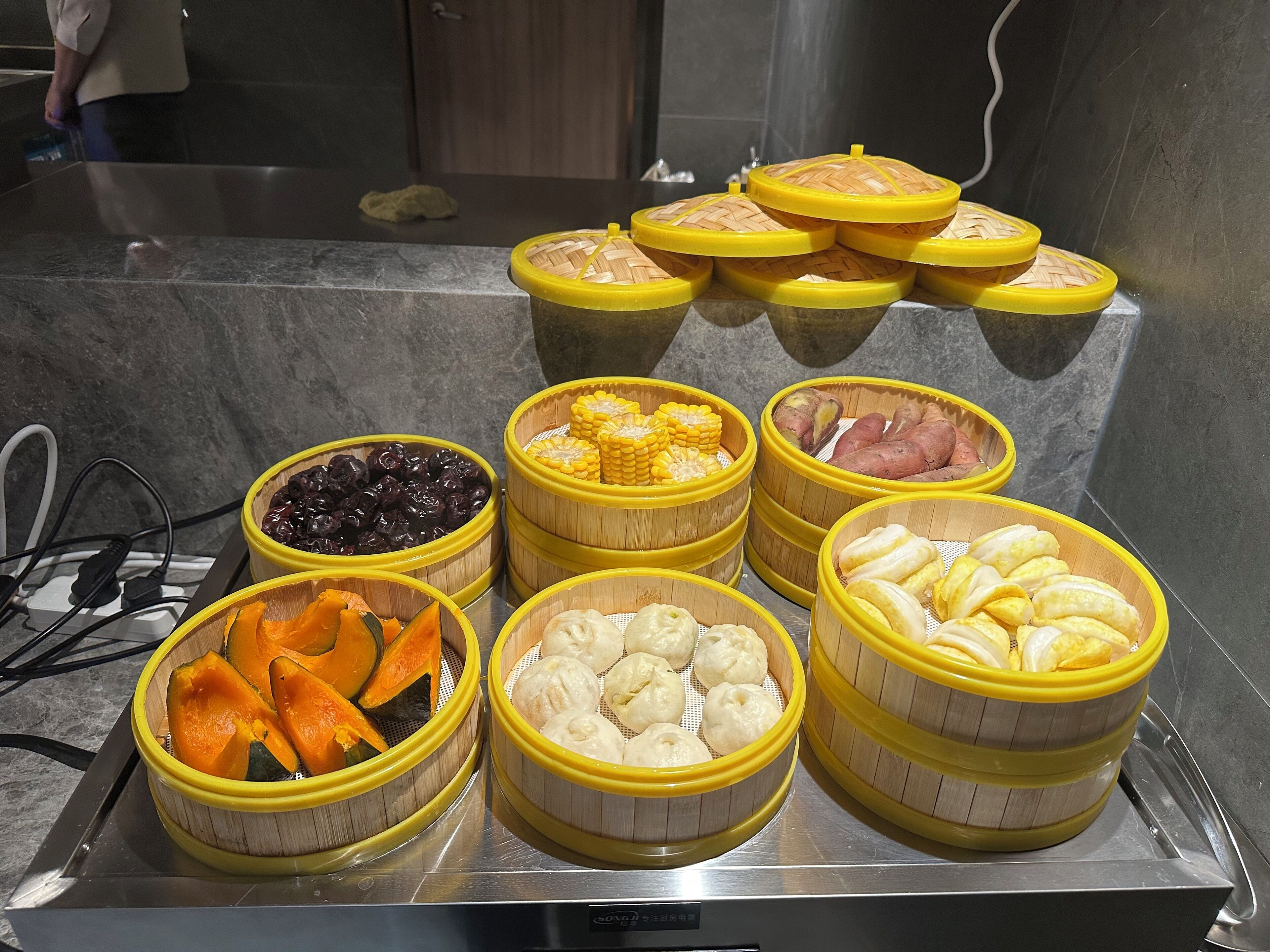 A buffet with various food items in bamboo steamers.