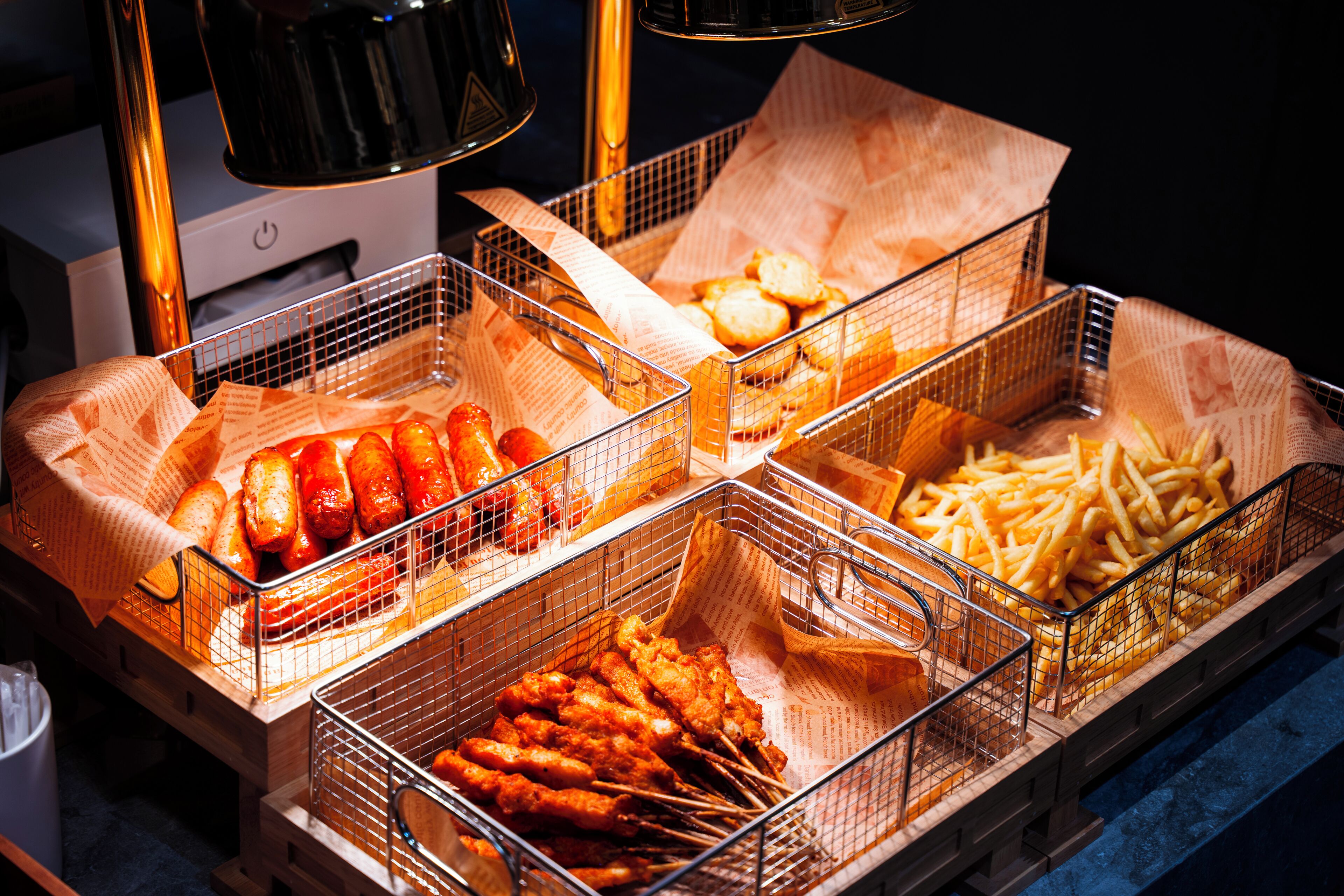 Una exhibición de comida con diversas preparaciones fritas en cestas.