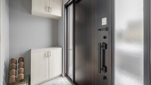 Une pièce dotée d’une porte coulissante, d’une armoire blanche et d’un porte-chaussures.