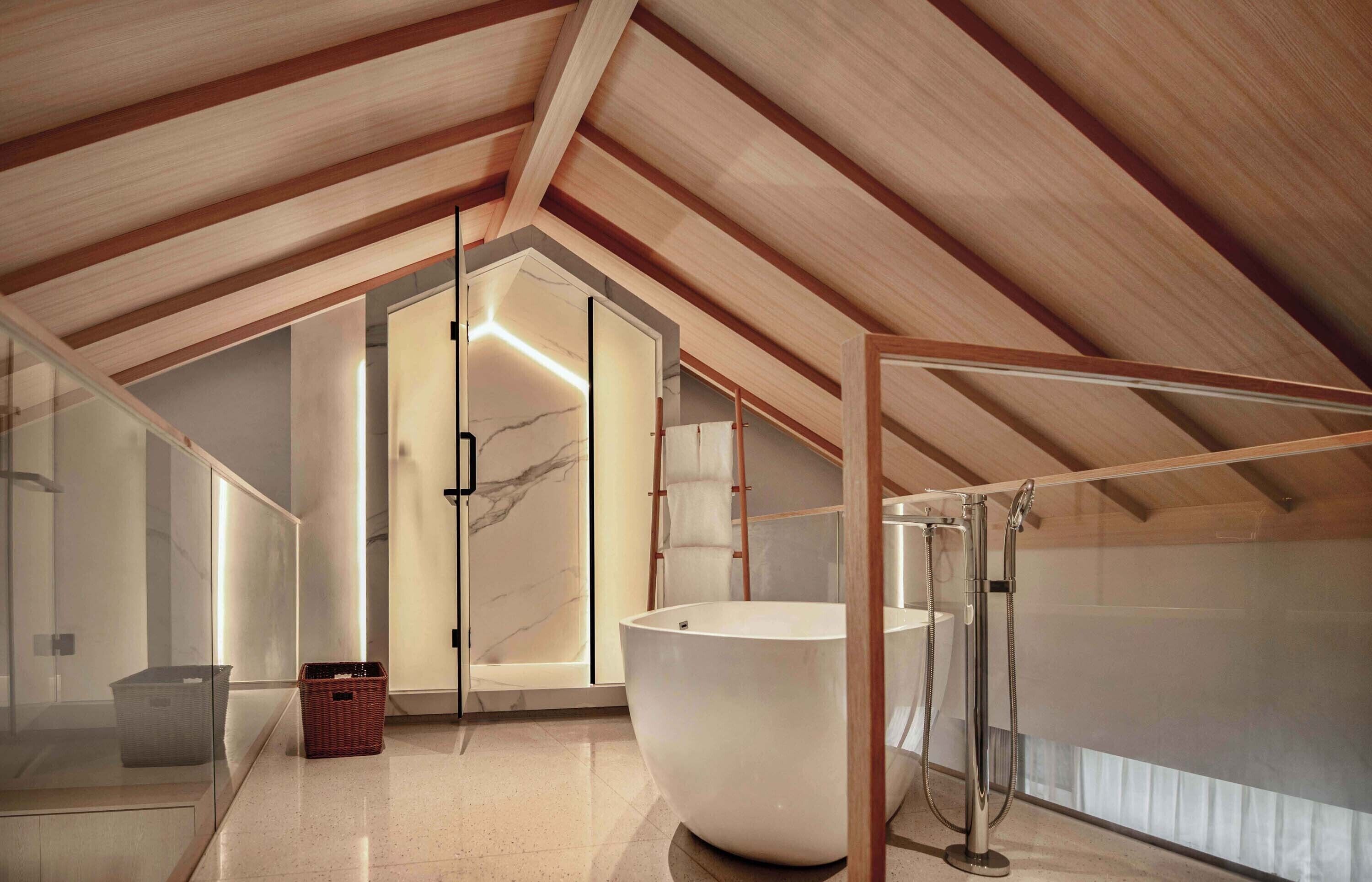 Un baño moderno con una bañera grande, cabina de ducha con paredes de cristal y techo de madera.