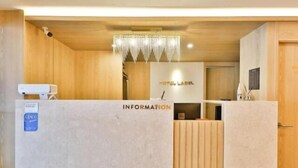 A reception area with a wooden reception desk, a chandelier, and a sign labeled "HOTEL LABEL". - Hotel Label Seongnam (Seongnam)