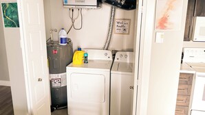 Een praktische wasruimte met een wasmachine, droger en boiler.