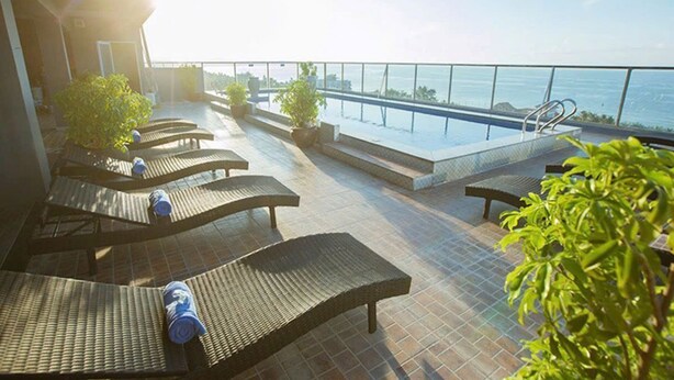 A rooftop terrace with sun loungers, a pool, and a view of the sea. - Palette Muine Boutique Hotel Near Mui Ne Beach (1 Bao Loc)